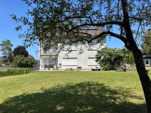 a white house with a tree in front of it at Ferienwohnung Eyb in Ansbach