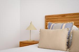 a bedroom with a bed with pillows and a lamp at Home on Rua da Alegria in Bicas
