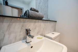a bathroom with a white sink and a toilet at Exquisite Serviced Studio @ Greenhead Central in Huddersfield +18 photos