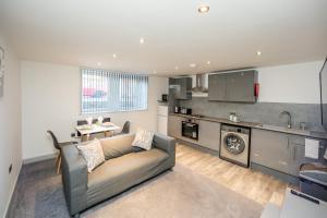 a living room with a couch and a kitchen at Exquisite Serviced Studio @ Greenhead Central in Huddersfield