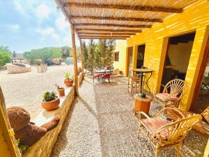 a patio with a teddy bear and tables and chairs at Eco-Ranch Salomé in Sidi Kaouki