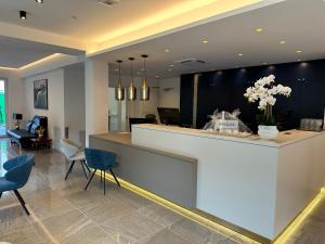 a lobby with a reception counter and blue chairs at Hotel Asgard in Zinnowitz +46 photos