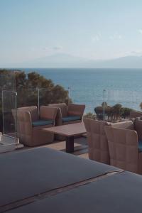 a patio with chairs and a table and the ocean at Didimos Town Hotel in Reggio Calabria