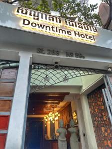 金边Downtime Hotel Phnom Penh的前面有两座雕像的建筑