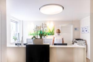 a woman wearing a face mask in a kitchen at Candlewood Suites Fürth by IHG in Fürth