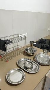 eine Theke mit vier silbernen Tellern auf einem Tisch in der Unterkunft Studio Apartment - 4pax - Hiranandani Estate in Thane