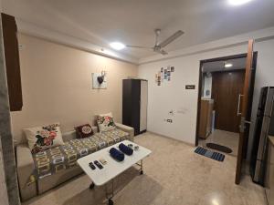 ein Wohnzimmer mit Sofa und Tisch in der Unterkunft Studio Apartment - 4pax - Hiranandani Estate in Thane + 36 Fotos