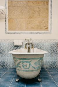 a bath tub in a bathroom with blue tiles at Pazo Almuzara in Boborás