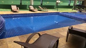 a large swimming pool with chairs and a table at Beach Place ACONCHEGO e refúgio perto do mar in Cumbuco