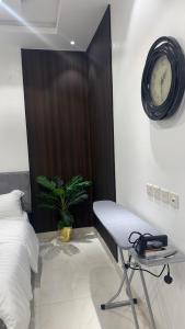 a bedroom with a desk and a clock on the wall at استديو بوصول ذاتي غرفتين in Jazan