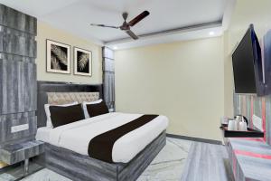 um quarto com uma cama e uma TV de tela plana em Townhouse Central Prayagraj Bus Terminal Formerly Amba Palace em Civil Lines