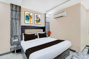 um quarto com uma cama grande branca e preta em Townhouse Central Prayagraj Bus Terminal Formerly Amba Palace em Civil Lines