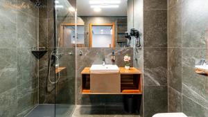 une salle de bain avec lavabo et douche dans l'établissement Wonder Hill - apartamenty z klimatyzacją, balkonami lub trasami, à Sosnówka
