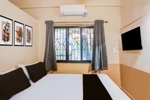 een slaapkamer met een bed en een raam bij Hotel O Arambol Beach Formerly Hakuna Matata in Arambol