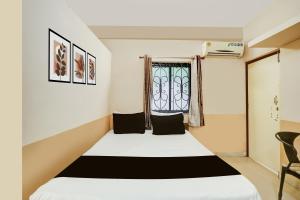 een slaapkamer met een wit bed en een raam bij Hotel O Arambol Beach Formerly Hakuna Matata in Arambol