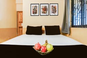 een slaapkamer met een bed met een schaal fruit erop bij Hotel O Arambol Beach Formerly Hakuna Matata in Arambol