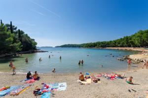 een groep mensen op een strand in het water bij House Klaudio in Štanga +19 foto's