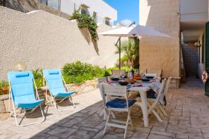 a table with chairs and an umbrella on a patio at Costal Vibe in Isola della Malva