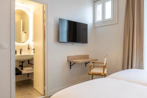 ブローニュ・ビヤンクールにあるDantan Hôtelの壁にテレビがあるホテルの部屋 +31枚の写真