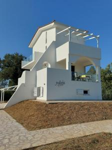 a white house with a staircase in front of it at House Piloda in Néa Thésis