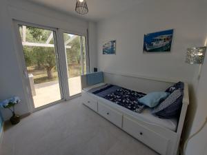 a bed in a room with a large window at House Piloda in Néa Thésis