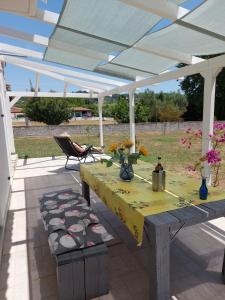 a table and chairs under a white pergola at House Piloda in Néa Thésis
