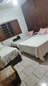 een slaapkamer met 2 bedden en een tegelvloer bij POUSADA ELSHADAY Centro in Osvaldo Cruz