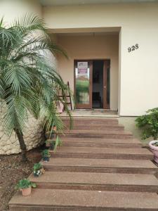 a stairway leading to a building with a palm tree at POUSADA ELSHADAY Centro in Osvaldo Cruz