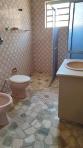 een badkamer met toilet, wastafel en douche bij POUSADA ELSHADAY Centro in Osvaldo Cruz