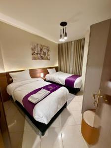 a hotel room with two beds and a window at D3S 3BR Apartment in Makkah