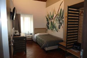 a bedroom with a bed and a painting on the wall at La Murata da Pedro in Coppito