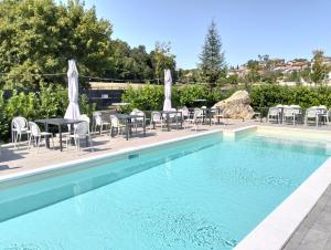 a swimming pool with chairs and a table and a table and chairs at La Murata da Pedro in Coppito +16 photos