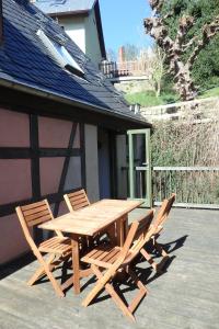 a wooden table and chairs on a patio at Ferienhaus Altes Elbschifferhaus in Königstein an der Elbe +8 photos