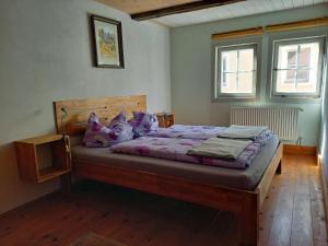 a bedroom with a bed with purple sheets and pillows at Ferienhaus Altes Elbschifferhaus in Königstein an der Elbe