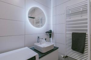 a white bathroom with a sink and a mirror at Ostwald - Tram à 4min et 20min du centre de Stras - Confort familial in Ostwald +48 photos