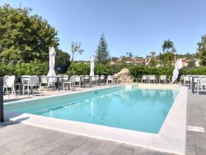 a swimming pool with tables and chairs next to a resort at La Murata da Pedro in Coppito
