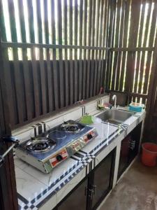 a kitchen counter with a stove and a sink at Izzahjay homestay in Burgos
