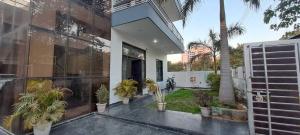 a house with potted plants on the side of it at Hotel O Naveen Residancy in Manesar