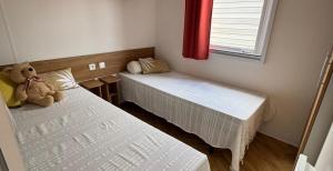 twee bedden in een kamer met een teddybeer erop bij Mobil Home 40m2, Bonne Anse Siblu 4 étoiles in Les Mathes +4 foto's