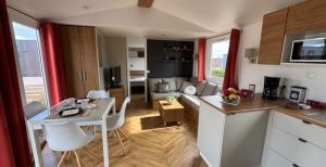 een keuken en een woonkamer met een bureau en een tafel bij Mobil Home 40m2, Bonne Anse Siblu 4 étoiles in Les Mathes