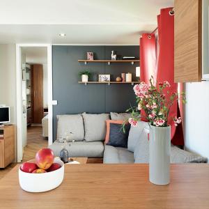 een woonkamer met een bank en een fruitschaal op een tafel bij Mobil Home 40m2, Bonne Anse Siblu 4 étoiles in Les Mathes