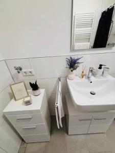 a white bathroom with a sink and a mirror at Zentrales, neumodernes Apartmentment Püttquartier No 3 in Ibbenbüren