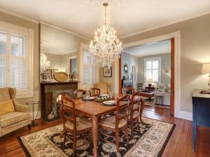 a dining room with a table and chairs and a chandelier at Luxury on Lincoln in Savannah