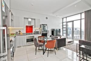 a kitchen with a table and chairs in a room at The Median Serviced Apartment Collection in Johannesburg
