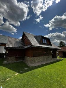una casa de madera con techo en un patio en Chatka Zuberec, en Tvrdošín 18 fotos más