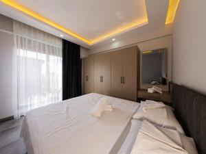 a bedroom with a large white bed with towels on it at Dorado Suit in Aksu +91 photos