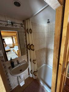 un baño con lavabo y bañera en Chatka Zuberec, en Tvrdošín