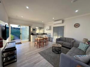 a living room with a couch and a table at Blueberry Hills On Comleroy Farmstay - Self-Contained Cottages in Kurrajong