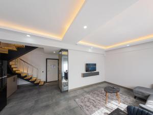 a living room with a couch and a staircase at Dorado Suit in Aksu