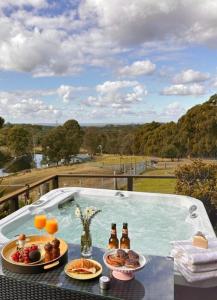 a table with two plates of food and bottles of beer at Blueberry Hills On Comleroy Farmstay - Self-Contained Cottages in Kurrajong